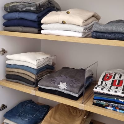 בגדים מקופלים בארון עץ עם מדפים