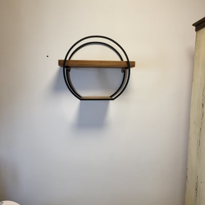 מדף עץ עגול עם מסגרת מתכת על קיר