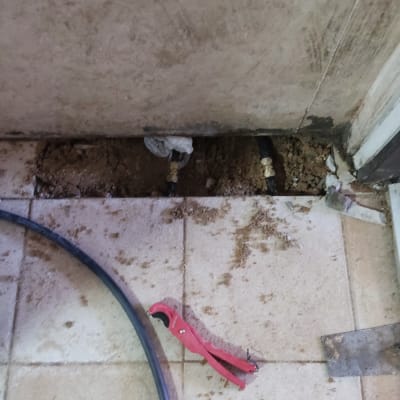 כלי חיתוך אדום וצינור שחור על רצפה