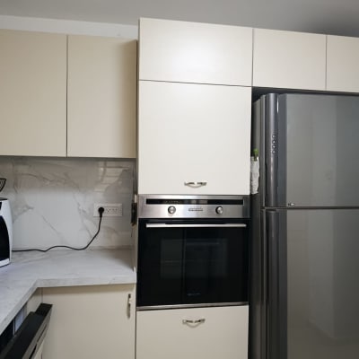 מטבח עם מקרר, תנור ומכשיר חשמלי על השיש