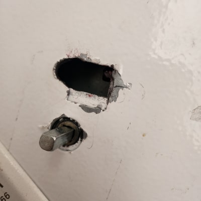 חור בקיר עם בריח מתכת חשוף