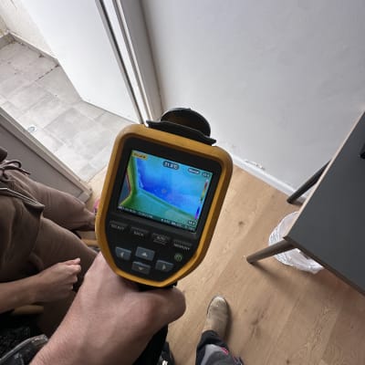 מד חום תרמי בשימוש לבדיקה ליד דלת