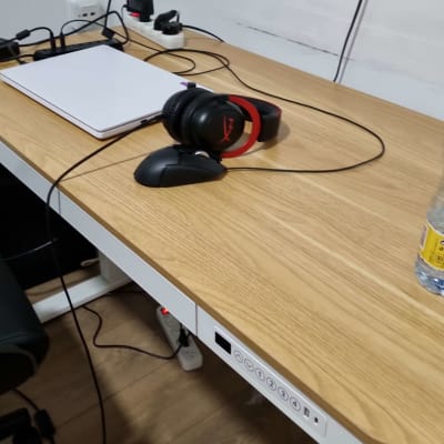 שולחן עץ עם אוזניות, עכבר ומחשב נייד