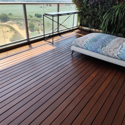 רצפת עץ במרפסת עם צמחייה וריהוט גן