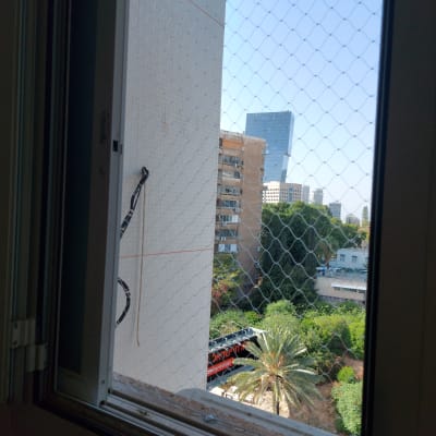 רשת נגד יונים מותקנת על חלון פתוח