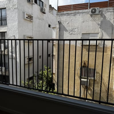 מעקה ברזל במרפסת עם בניינים ברקע