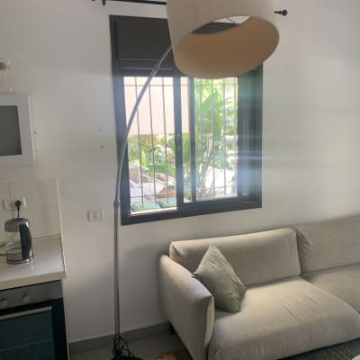 מנורת קשת עומדת ליד ספה אפורה