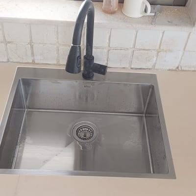 כיור נירוסטה עם ברז על משטח שיש בהיר