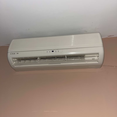 מזגן קיר לבן מותקן על קיר פנימי