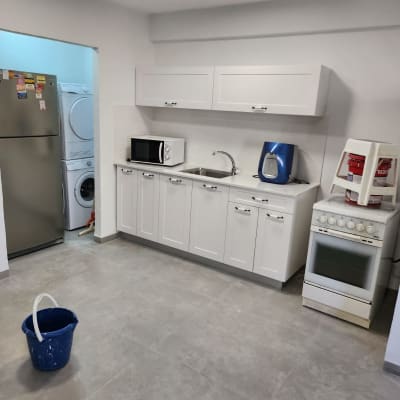 דלי כחול על רצפה חדשה במטבח משופץ