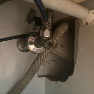 צינור מים מתחת לכיור עם ברזים וחיבורים