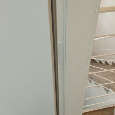 דלת לבנה עם מסגרת מתכת ליד מדרגות