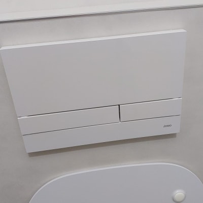 לחצן הדחה כפול על קיר חדר אמבטיה