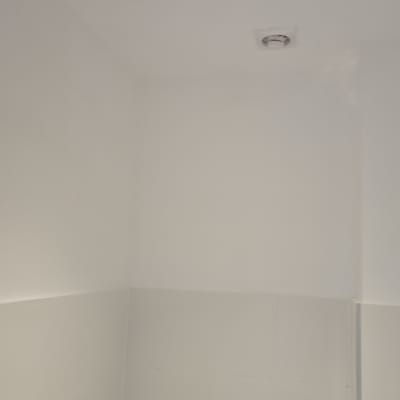 קיר צבוע בלבן עם תאורה בתקרה