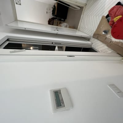 דלי צבע אדום, מברשת, קרטון על הרצפה