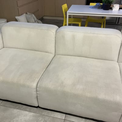 ספה בהירה עם סימני ניקוי, שולחן וכיסאות ברקע