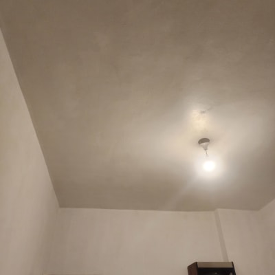 תקרה חלקה עם נורה תלויה במרכז החדר