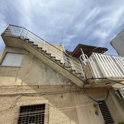 מבנה עם מדרגות חיצוניות וקירות טיח