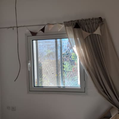 חלון עם וילון פתוח ושרשרת דגלונים