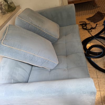 ספה כחולה עם צינור ניקוי על הרצפה