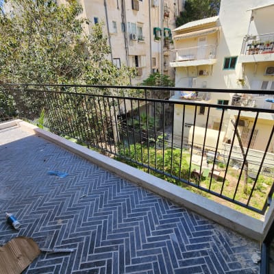 מעקה מתכת במרפסת עם רצפת אריחים