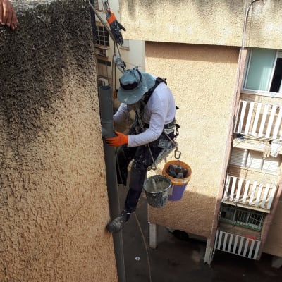 אדם על גג עם ציוד תיקון ואבטחה