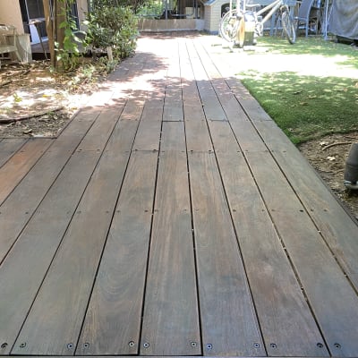 שביל עץ בגינה עם דשא ועצים מסביב