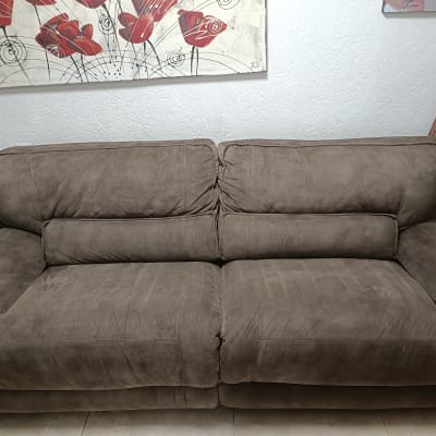 ספה חומה עם כריות, תמונה של פרחים על הקיר