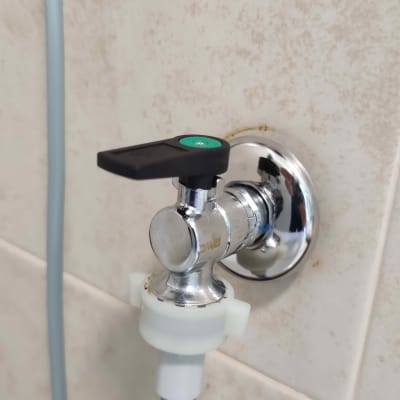 ברז מתכת עם ידית שחורה וצינור מחובר