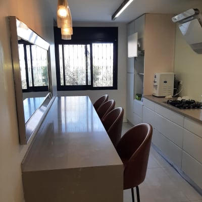 מטבח נקי ומסודר עם כיסאות ושולחן בר