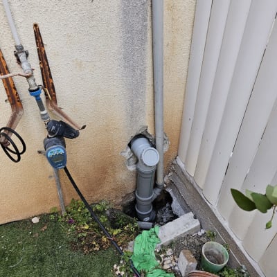 צינור פלסטיק אפור מחובר לקיר עם חיבורים