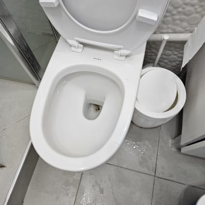 אסלה פתוחה עם מים על הרצפה ליד