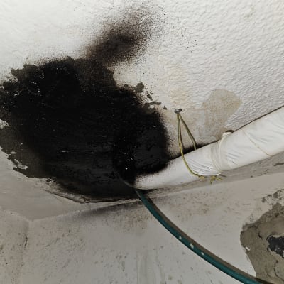 נזילה בתקרה עם צינור ירוק ולבן