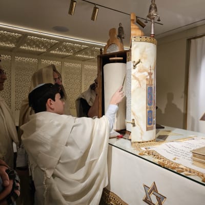 אדם קורא בספר תורה בבית כנסת