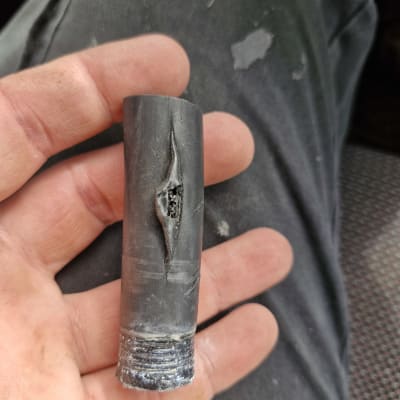 צינור גומי שחור עם קרע ביד אדם