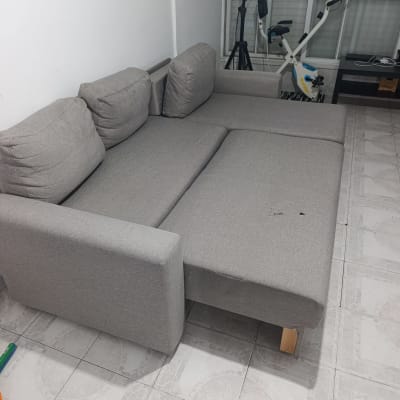 ספה אפורה בחדר עם אופני כושר ומנורת חימום