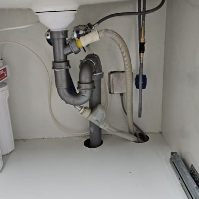 צנרת מתחת לכיור עם חיבורים וצינורות