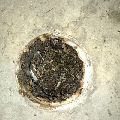 פתח ניקוז סתום עם לכלוך וחומרים שחורים