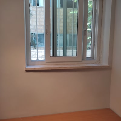 קיר צבוע בלבן ליד חלון עם תריסים