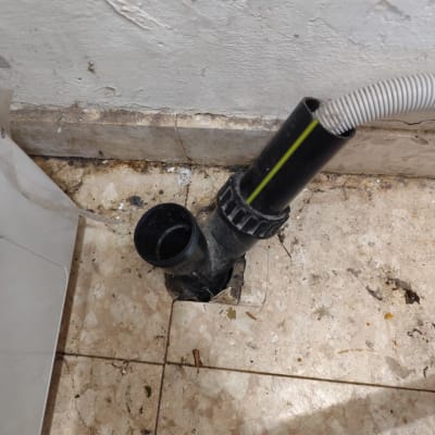 צינור ניקוז על רצפה מלוכלכת ליד קיר