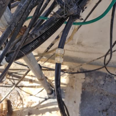 צינור שחור עם מחבר מתכת על רקע קיר