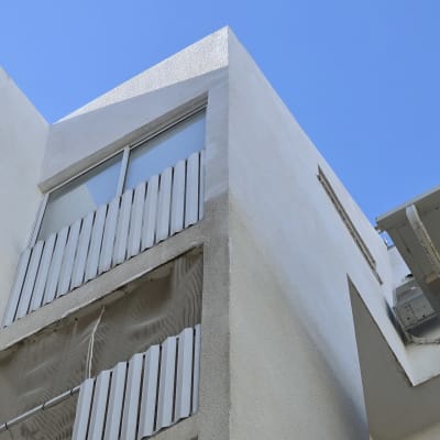 בניין עם חלונות ומזגן חיצוני על קיר לבן