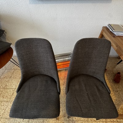 שני כיסאות אפורים על רצפה עם תנור חימום ביניהם