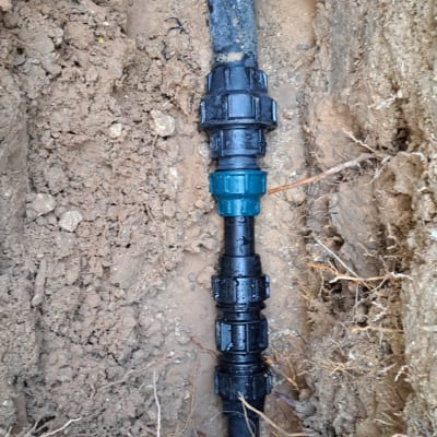 חיבור צינור פלסטיק באדמה עם מחבר שחור וכחול