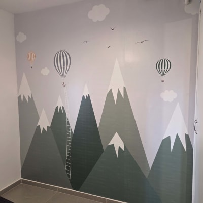 קיר מעוצב עם ציור של הרים ובלונים פורחים