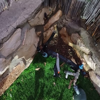 כלי עבודה וצינורות ליד קיר אבן