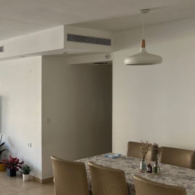 מנורה תלויה מהתקרה מעל שולחן אוכל