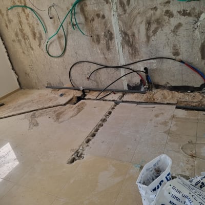 קיר גבס עם צינורות חשמל ומים חשופים