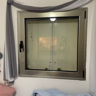 חלון עם מסגרת מתכת ומיטה בחדר שינה