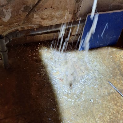 מים זורמים מצינור על רצפה רטובה